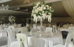 fine dining, white covered chairs and tables, centerpieces, marquee