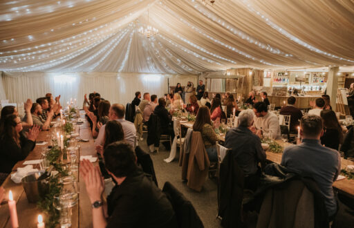 event in action, bar, people seated on chairs, tables, whiyte lights, white silk surrounding the event space