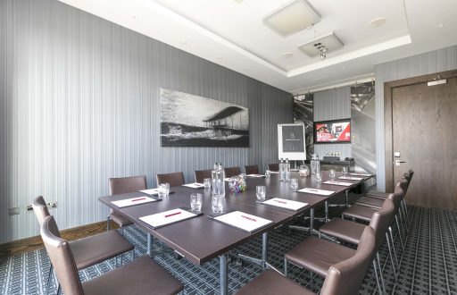 boardroom, brown leather chairs, tv screen, flipchart, grey meeting room