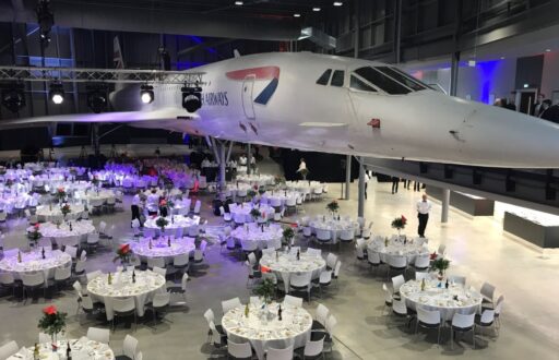 unique event space, cabaret layout, dinner set up, white tables under the wings of the supersonic passenger jet, Aerospace Bristol