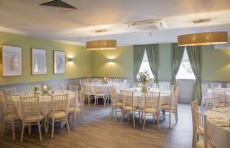 natural lighting, pastel green, wooden chairs, green curtains, banqueting layout