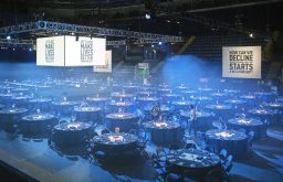 large exhibition & conference space, cabaret style, tables, stage centered in the middle, arena