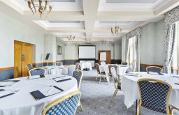 projector screen, flipchart, cabaret layout, conference room, natural daylight