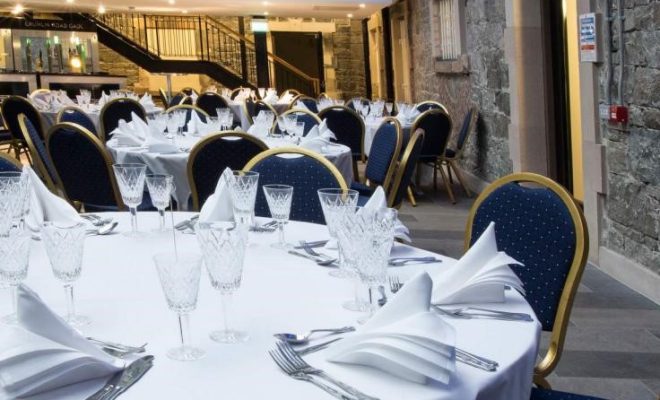nicely decrocrative napkins, fine glasses, cutlery, brick walls, stairs, tables, blue chairs