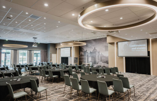 modern conference room, two projector screens, cabaret layout, natural lighting