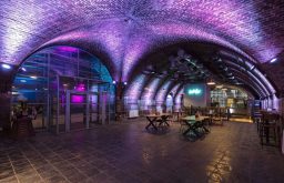 arch event venue, tables to the side, purple lighting