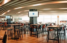 large event space, screens, high tables and stools, bar towards the back