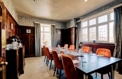 modern and historic style meeting room, boardroom layout, natural daylight, note pads, glasses, tea and coffee