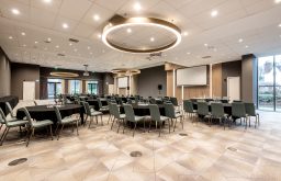 two projector screens, modern conference room, university hotel, circular celing lights, cabaret layout