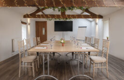rustic meeting room, TV screen, fairy lights, flipchart, boardroom layout