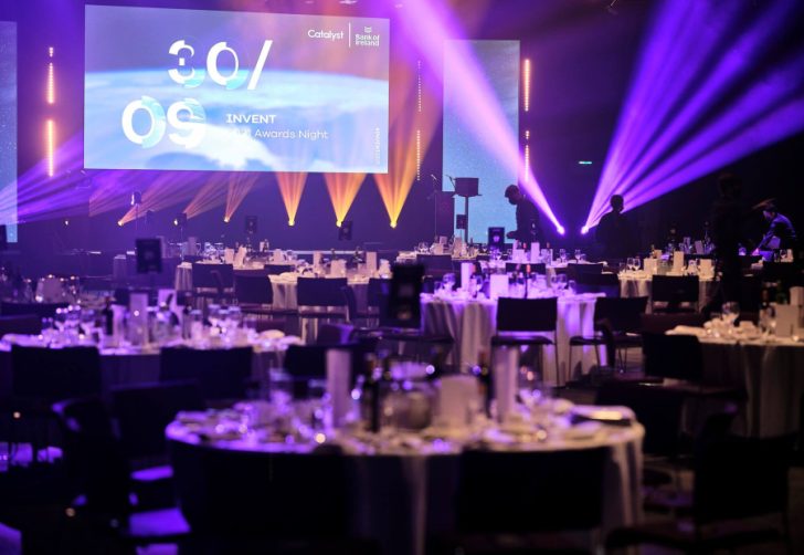gala dinner, purple and orange spotlights, darkly lit, belfast