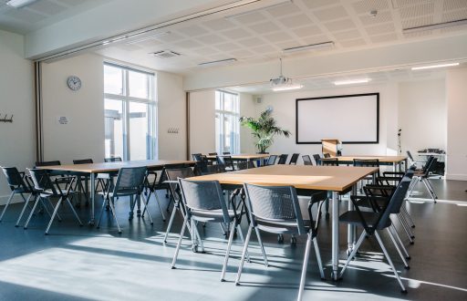 classroom layout, projector screen, lecturn, modern chairs, clock, conference room