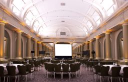 Projector screen in front, large conference room, plasma screens at the side, semi cabaret tables