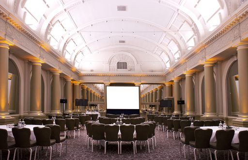 Projector screen in front, large conference room, plasma screens at the side, semi cabaret tables