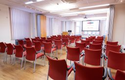 theatre style, projector screen, lecturn, red chairs, conference space