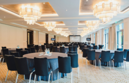 conference room, chandeliers, projector screens, two TV screens at the side, cabaret layout