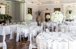 head table, decorated room, flowers, white tableclothed tables