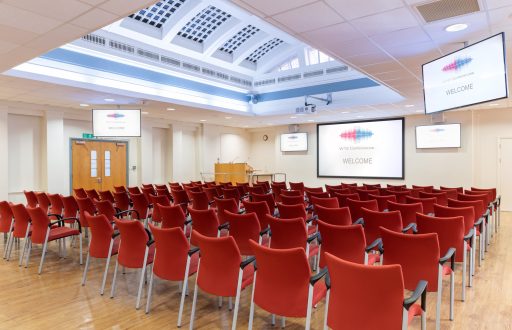 theatre style, projector screen, plasma screens, lecturn, red chairs, modern conference room