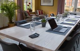 boardroom, meeting space, laptop, glass water bottle, garden door