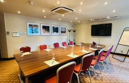 boardroom, flip chart, red chairs, large TV screen