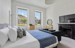 bedroom, accomodation, large flat screen, hotel suite, natural daylight, sofa in front of the TV