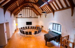 chairs facing in the circle, TV screen, piano