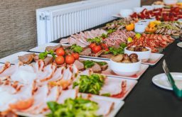 hot and cold food buffet, white platters on buffet table