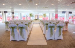 natural daylight, nicely presented chairs, head table, aisle, event space