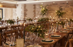 nicely decroated tables, dinner set up, wine and water glasses, plates and cutlery