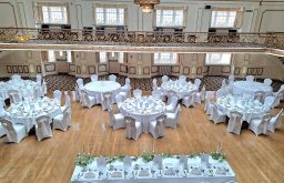 head table, white covered tables and chairs, balcony