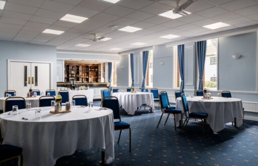 conference room, cabaret layout, glasses, refreshment table at the back in front of the bar, natural lighting