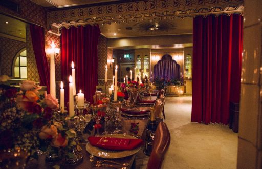 dimly lit room, private dinning area, intimate, red curtains, candles