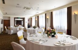 banquet, event space, white table cloths, wine bottle, flower decor