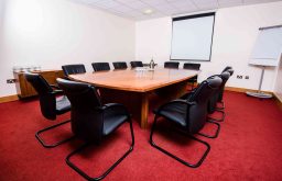 projector screen, flip chart, black leather meeting chairs, meeting rooms