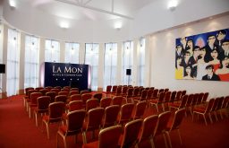 red chairs, theatre, lecturn, caricaturepainting on the wall