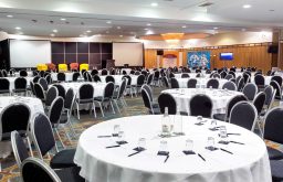conference room, two projector screens, water glasses on, conference stools, chairs