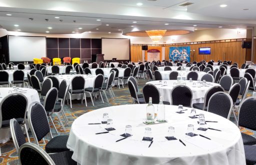 conference room, two projector screens, water glasses on, conference stools, chairs